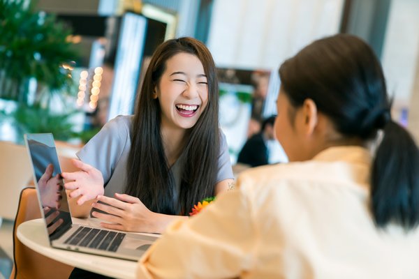 beautiful attractive business female present new project with smile and joyful to client with laptop and modern office background